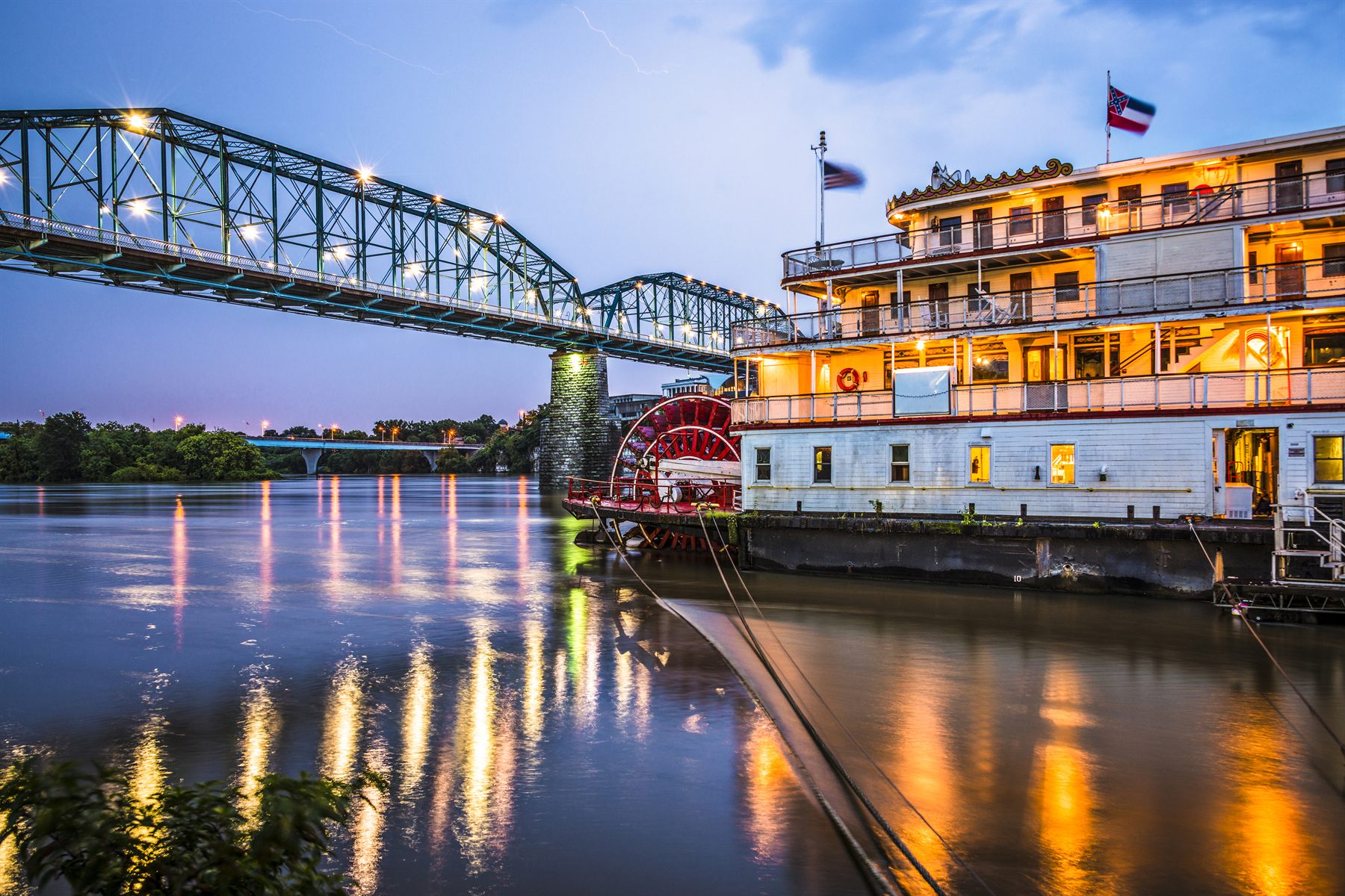 Sternwheeler moored beside a truss bridge in Chattanooga, Tennessee, at dusk